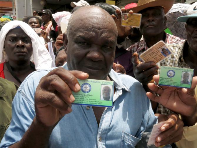 Un Haïtien montrant la carte qui prouve quil travaille dans une exploitation de canne à sucre depuis 1963