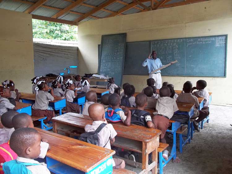 Un enseignant travaillant dans une salle de classe. Photo haitisupportgroup.org  1